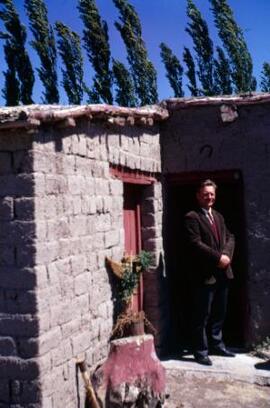 [Smartly dressed man standing outside his house]