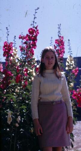[Teenage girl & hollyhocks]