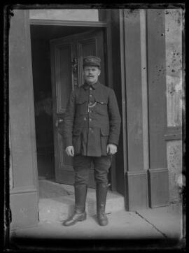 [Man standing in doorway wearing military winter hat]
