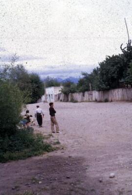 [Dusty road with the Andes beyond]
