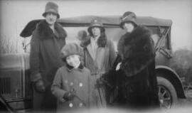 [Three women and a girl in hats and wintercoats]