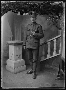 [Full-length studio portrait of a soldier standing to attention.]